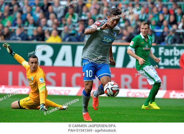 Hoffenheim's Roberto Firmino (C) scores 1-0 against Bremen's goal keeper Raphael Wolf (L) and Bremen's Izet Hajrovic (R) during the Bundesliga soccer match...