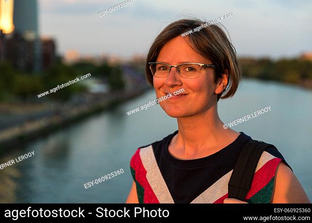 Portrait of an attractive 30 year old white woman at the river Main during sunset
