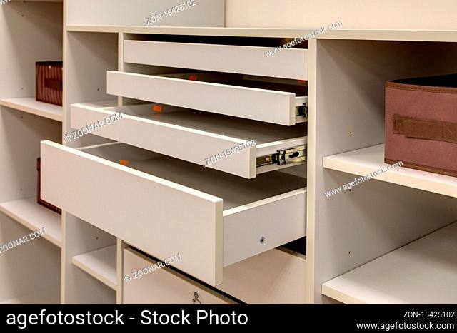Fragment of a dressing room with open shelves and cabinets