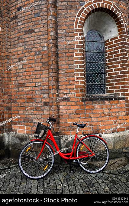 Aarhus, Denmark A red bicycle leaning up against the cathedral