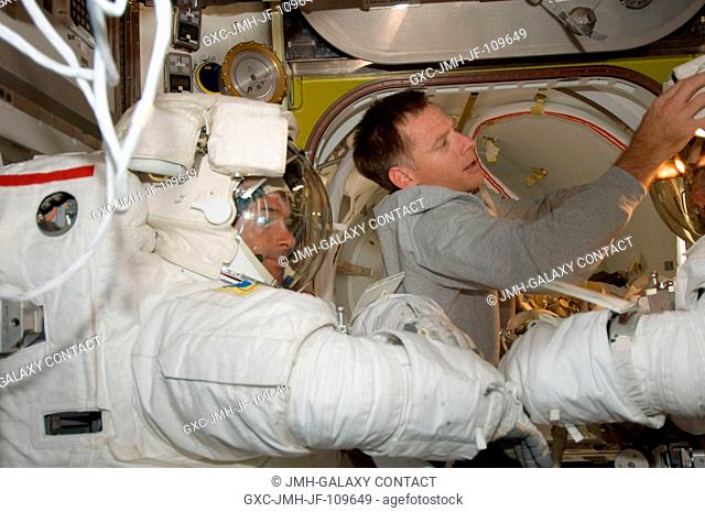 Astronauts Shane Kimbrough and Steve Bowen (right, mostly out of frame), both STS-126 mission specialists, attired in their Extravehicular Mobility Unit (EMU)...