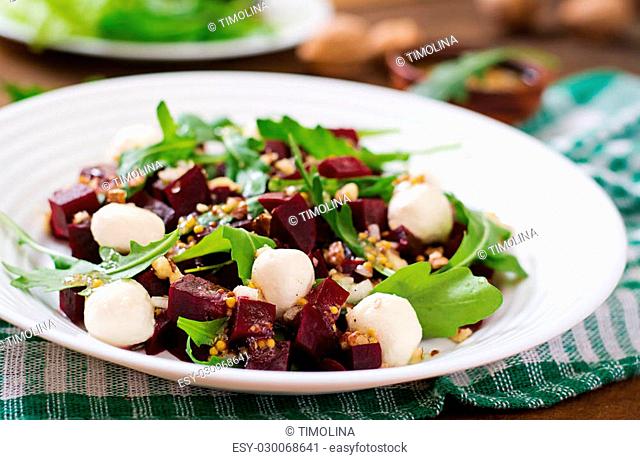 Salad of baked beets, arugula, cheese and nuts