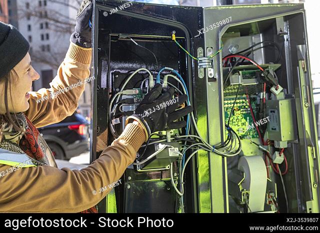 Detroit, Michigan - A worker examines the computerized control station in the docking station of Detroit's MoGo bike share system