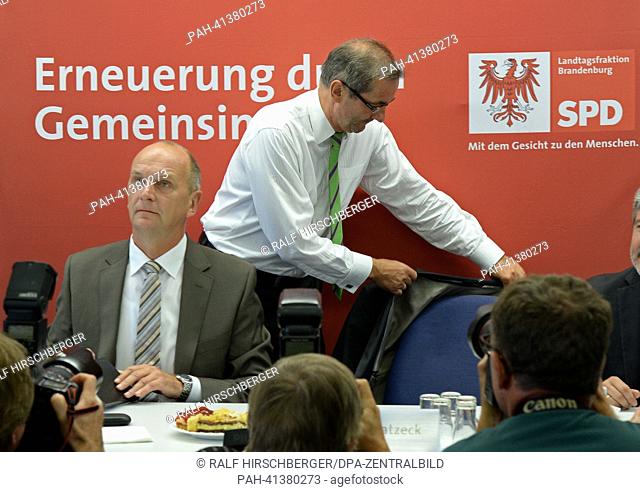 Premier of Brandenburg Matthias Platzeck (SPD, R) takes off his jacket next to his expected successor and current Brandenburg Minister of the Interior Dietmar...