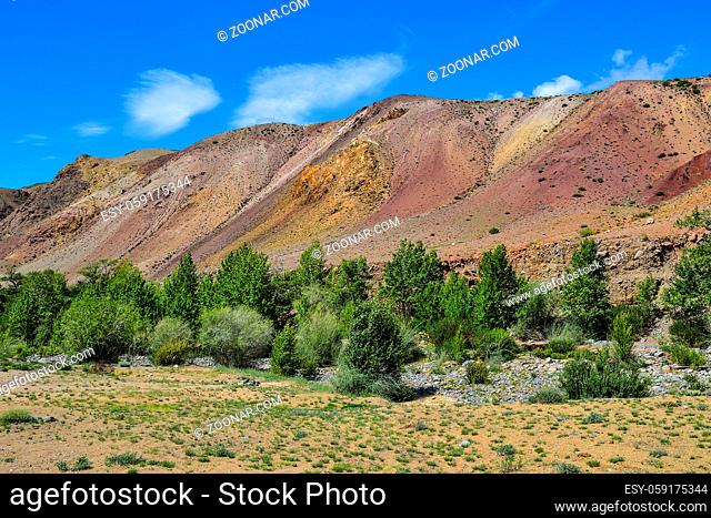 View of unrealy beautiful multi-colorful clay cliffs in Altai mountains, Russia. Summer landscape, which is called Martian and Kyzyl-chin valley with boulders...