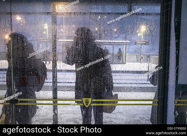 Stockholm, Sweden People waiting in a bus stop for a tram in a snowstorm