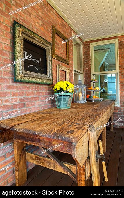 Old used and worn rustic wooden workshop bench in veranda at the back of an old 1900 Victorian Queen Anne revival style house, Quebec, Canada