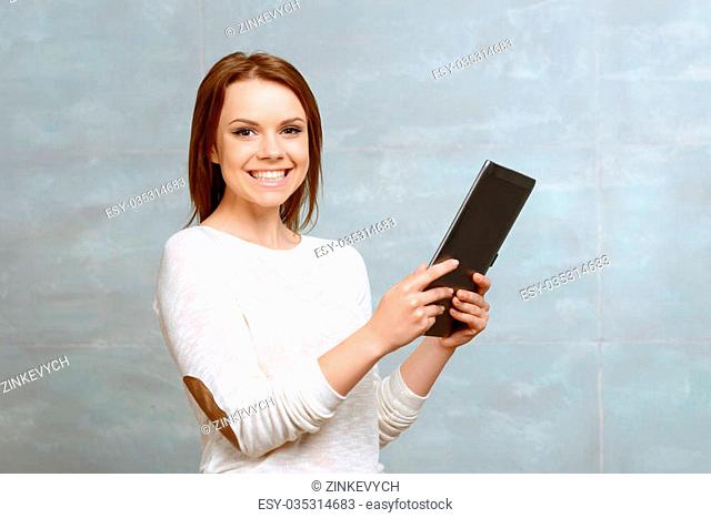 Funny toy. Pretty smiling lady holding her tablet on isolated background
