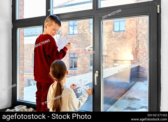 happy children decorating window on christmas