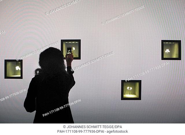 A woman taking a picture of a jewel box in a showroom of French jeweler Van Cleef & Arpels in New York, US, 07 November 2017
