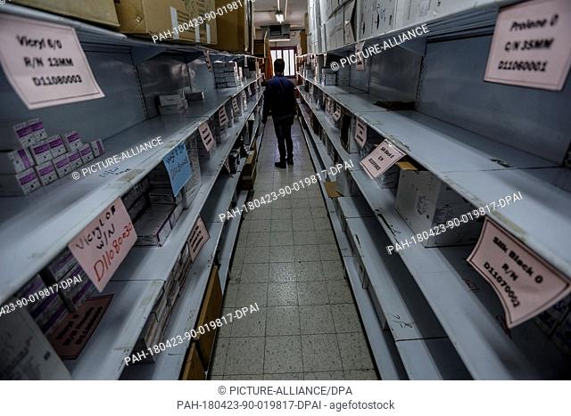 dpatop - A member of the medical staff stands amongst empty medicine shelves, amid major shortages of essential medicines for the wounded