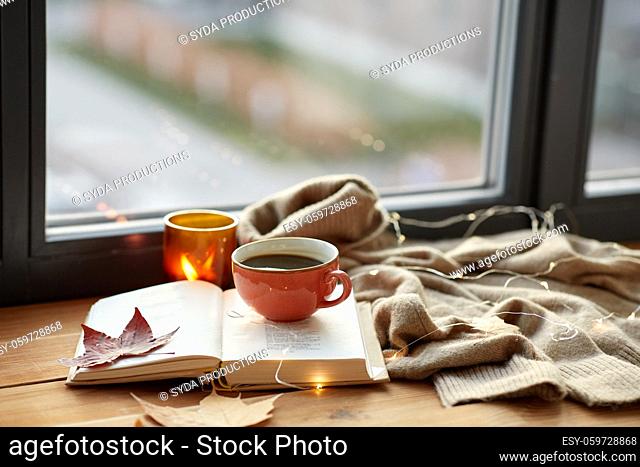 cup of coffee, book on window sill in autumn
