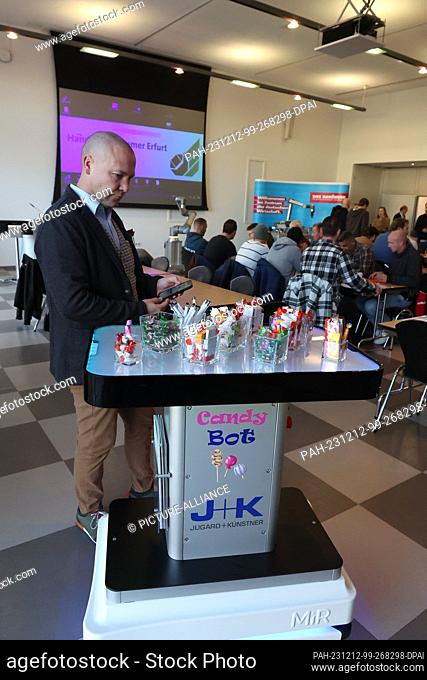 12 December 2023, Thuringia, Erfurt: Christian Held from Jugard+Künstner works at a robot service station at the launch event of the Competence Center for...