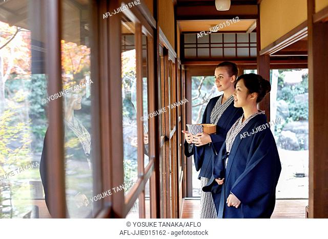 Caucasian woman wearing yukata with Japanese friend at traditional ryokan, Tokyo, Japan