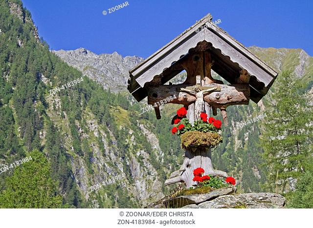 Idyllisches blumengeschmücktes Wegkreuz im Frosnitztal in Osttirol