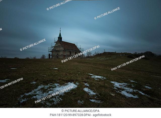 20 November 2018, Bavaria, Schlaifhausen: The last snow remains can be seen in the evening before the Walburgis Chapel on the Ehrenbürg known as ""Walberla""...