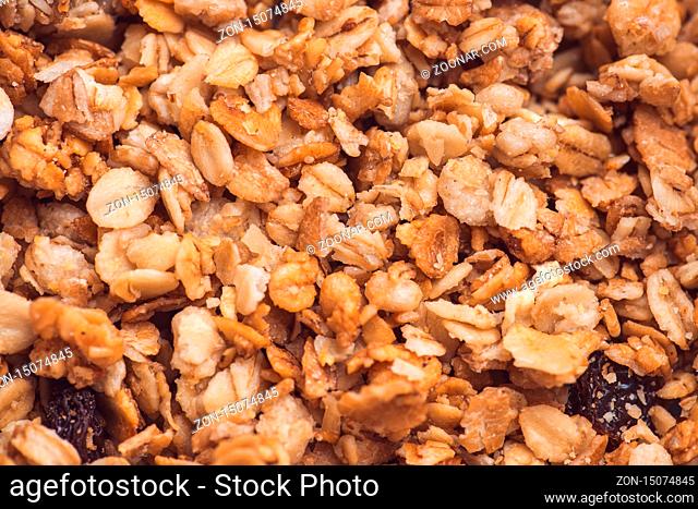 Useful and tasty muesli with nuts, rasins and flakes. Selective focus macro shot with very shallow depth of field. Healthy and vegetarian lifestyle