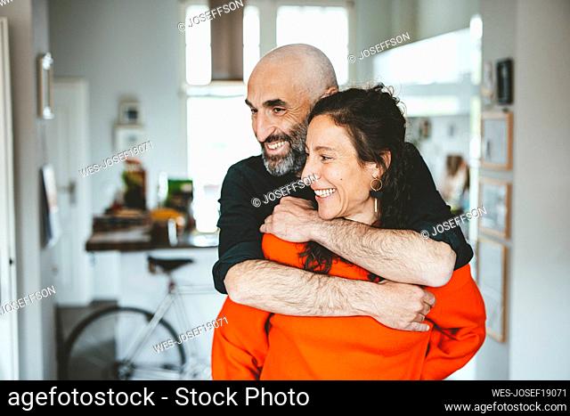 Happy man embracing woman at home