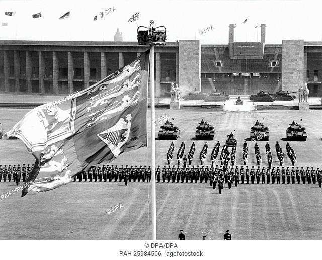 The Queen's standard blows on Maifeld in front of Olympia Stadium in Berlin on the 13th of June in 1964 during a parade of the British garrison in honour of...