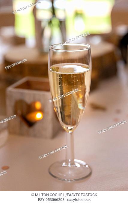 Love concept. Champagne glass with heart shaped candle holder in a wedding setting