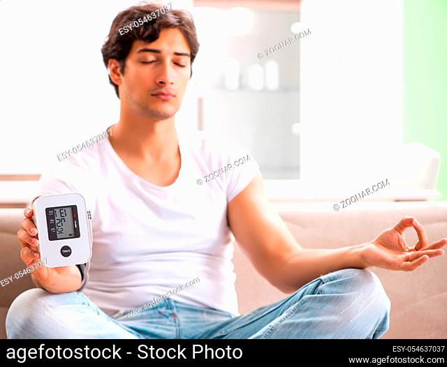 The young man measuring blood pressure at home