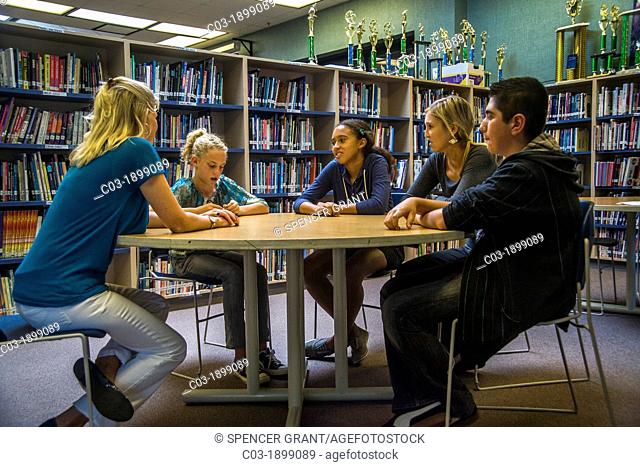 A junior high school counsellor meets with a multiethnic group of students in a San Clemente, CA, school library