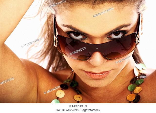 blond young woman looking into the camera over her sport sunglasses with bedroom eyes