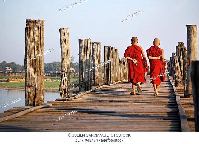 Two young monks crossing U Bein bridge. Myanmar, Mandalay, Amarapura, U Bein