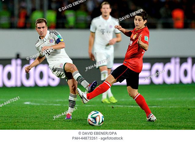 Philipp Lahm (L) of Bayern Munich and Dario Conca of Guangzhou vie for the ball during the FIFA Club World Cup semi final soccer match between Guangzhou...