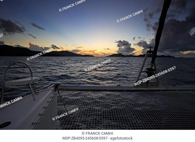 view from a sailling boat of a sunset on saint anne 's bay inpraslin seychelles islands indian ocean