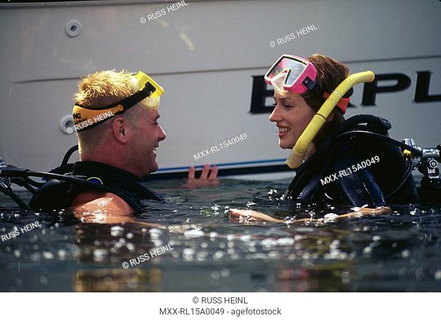 scuba divers taking beside boat