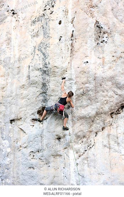 Thailand, Krabi, Chong Pli, woman climbing in rock wall