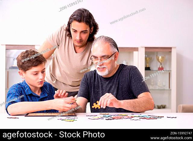 Three generations of family playing jigsaw puzzle