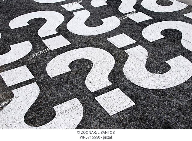 question mark signs painted on a asphalt road surface