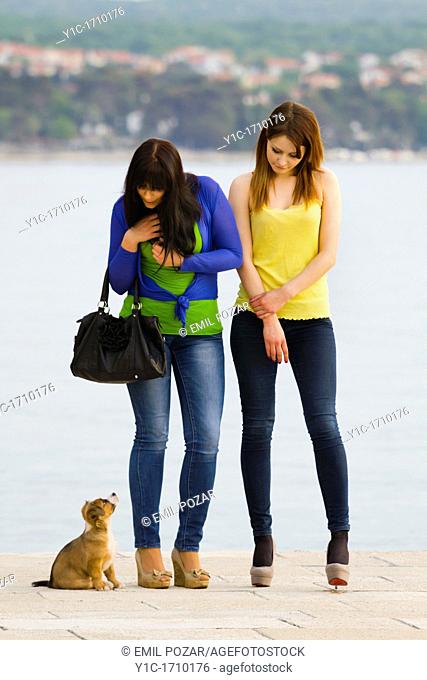 Two young women and a small dog