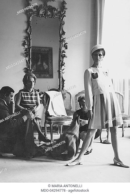 Italian fashion designer Maria Antonelli in the fashion show room. Beside her, her daughter Luciana and her son-in-law checking the clothes
