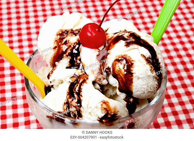Vanilla Ice Cream and Spoons with Cherry and Chocolate Topping Closeup