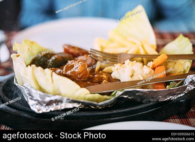 Goa, India. Dish Of Indian National Cuisine Is Sizzler, Which Consist Of French Fries, Fried Shrimp In Sauce, Fried Vegetables