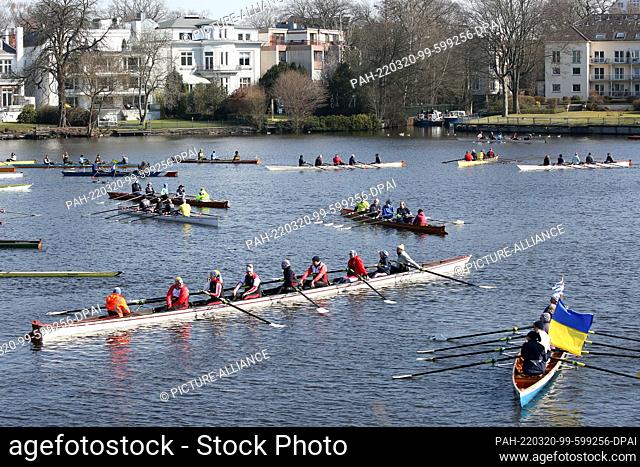 20 March 2022, Hamburg: Rowers are in boats at a peace demonstration against the war in Ukraine on the Outer Alster, not far from the Russian Consulate General