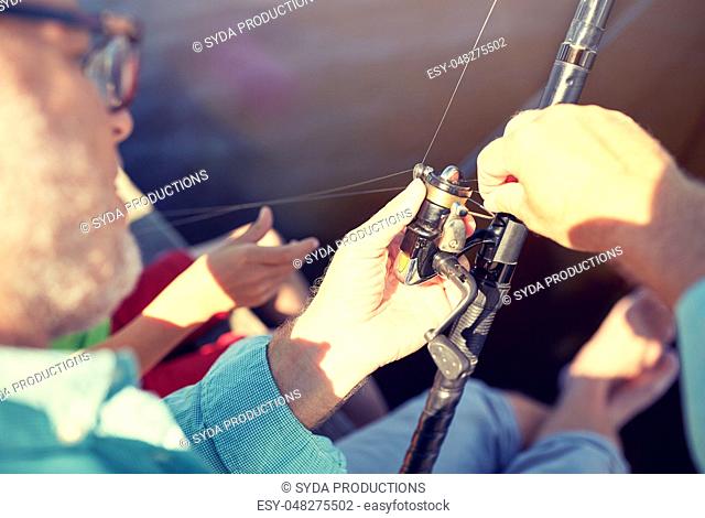 senior man with fishing rod or spinning on river