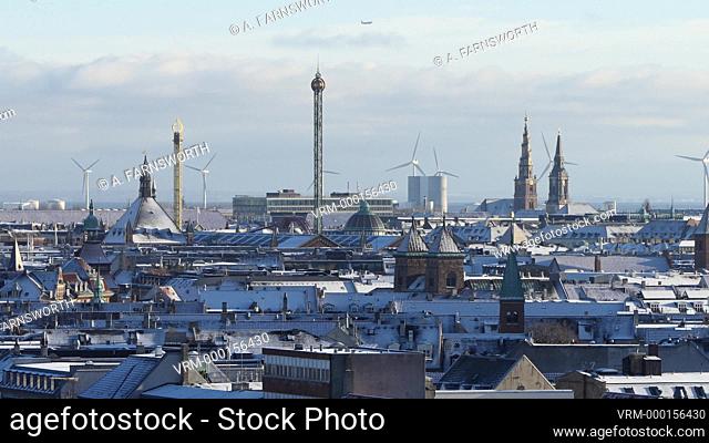 Copenhagen, Denmark Snow covers the rooftops of the city skyline, church spires, and wind turbines