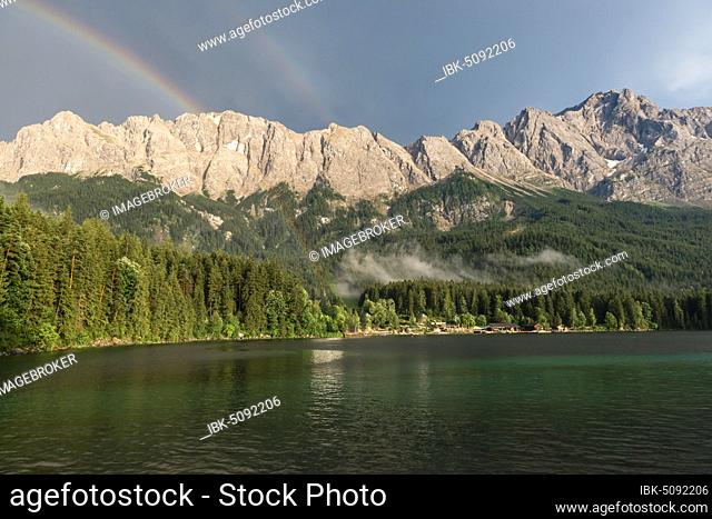 Rocks on the shore, Eibsee lake in front of Zugspitze massif with Zugspitze with double rainbow, Wetterstein range, near Grainau, Upper Bavaria, Bavaria