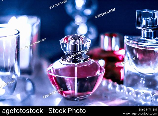 Perfumery, cosmetics branding and luxe concept - Perfume bottle and vintage fragrance on glamour vanity table at night, pearls jewellery and eau de parfum as...