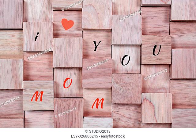 wood background : message I love you mom spelled in wooden block