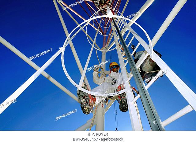painter rappelling from a pole in dizzy altidude, France