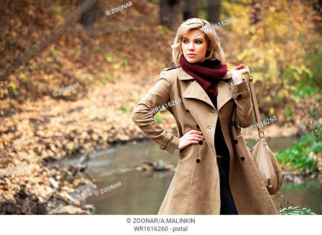 Young blond woman in autumn forest