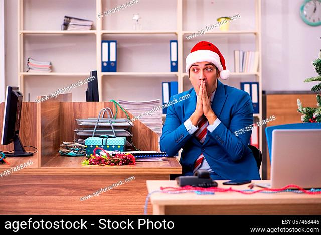 Young male employee celebrating Christmas in the office