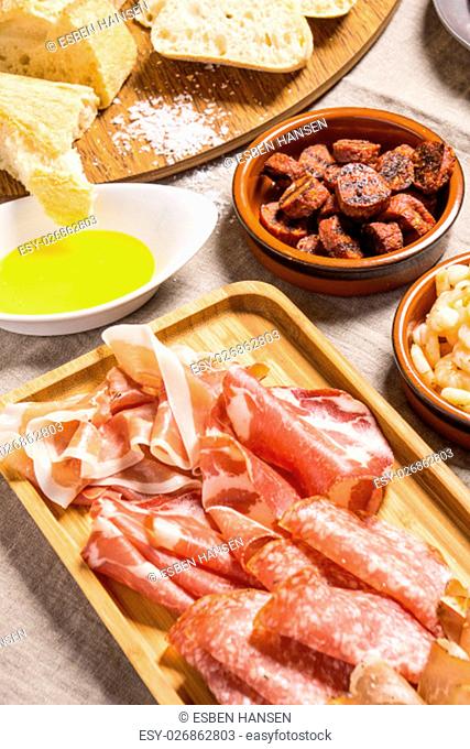 Tapas food, served in small bowls cold meat, goat cheese. A meal for sharing