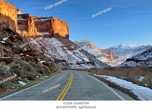 Highway 128 and red rock formations with snow near sunset in winter, Colordao Riverway Recreation Area, Utah, USA