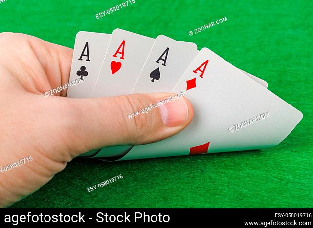 Hand with playing cards in casino - gambling background